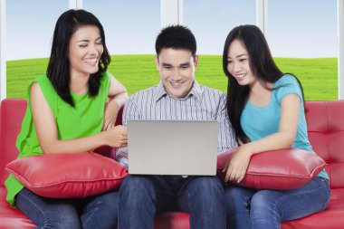 Kanepe üstünde laptop ile arkadaş grubu