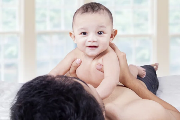 Izgatott baba játszik apa gyomor az ágyban — Stock Fotó