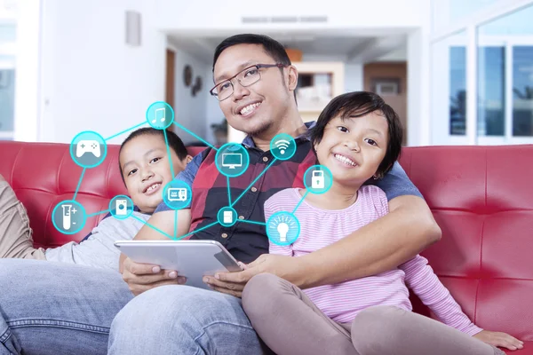 Familia usando controladores inteligentes de la casa y sonriendo —  Fotos de Stock