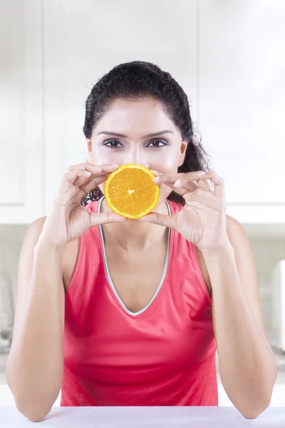 Modelo feminino detém pedaço de fruta laranja — Fotografia de Stock
