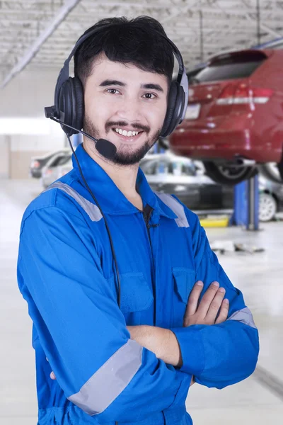 Mecánico masculino con auriculares en taller —  Fotos de Stock