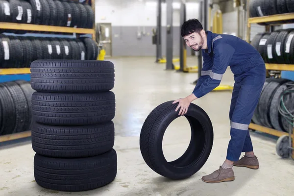 Mekanikern bär ett däck — Stockfoto