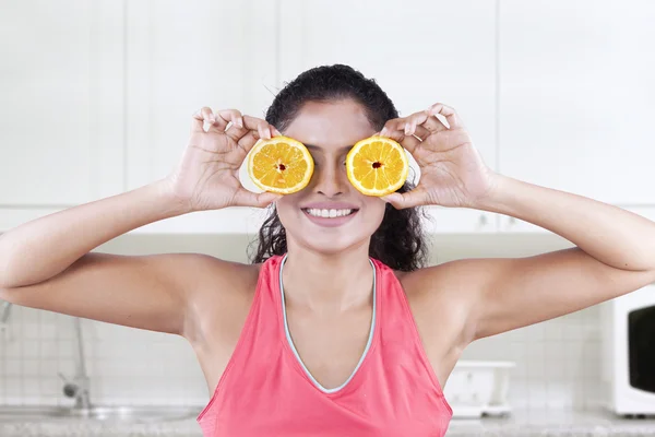 Modelo fecha os olhos com pedaços de laranja — Fotografia de Stock