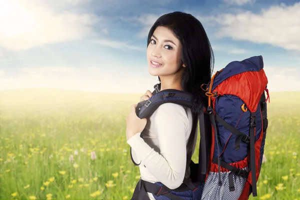 Aziatische vrouw met hiking tas op weide — Stockfoto