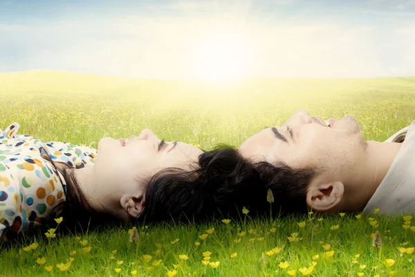 Two lovers lying on grass and look at sky — Stock Photo, Image