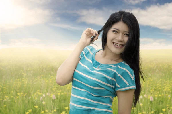 Mujer con el pelo largo sonriendo en el prado — Foto de Stock