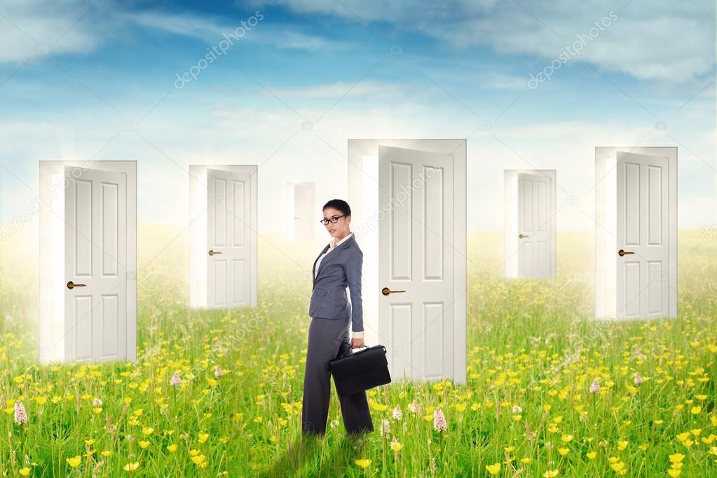 Businesswoman and open doors at field