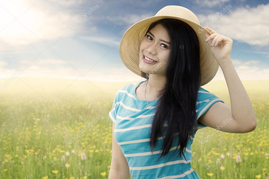 Pretty Asian girl with hat in nature