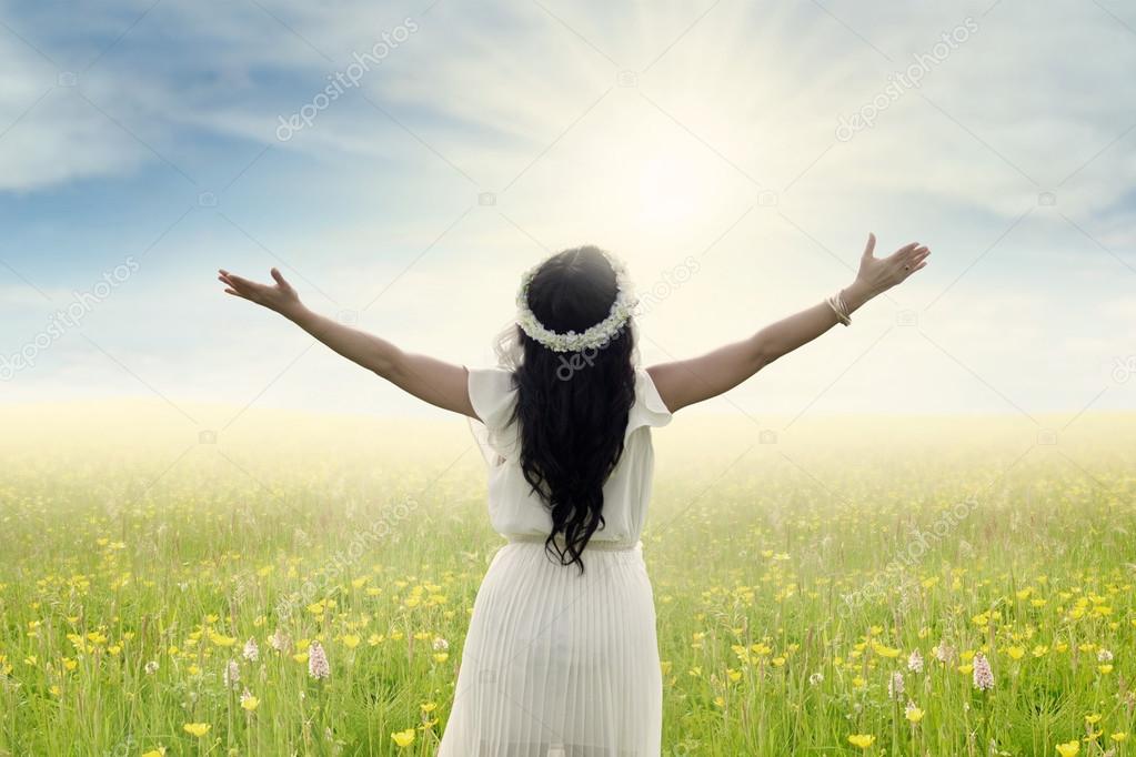 Woman with outstretched hands on meadow