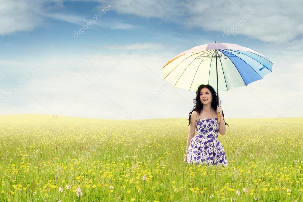 Young woman with umbrella in nature