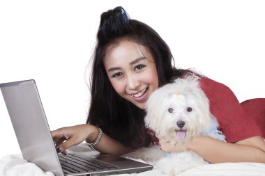 Köpek ve yatak üstünde laptop ile neşeli modeli
