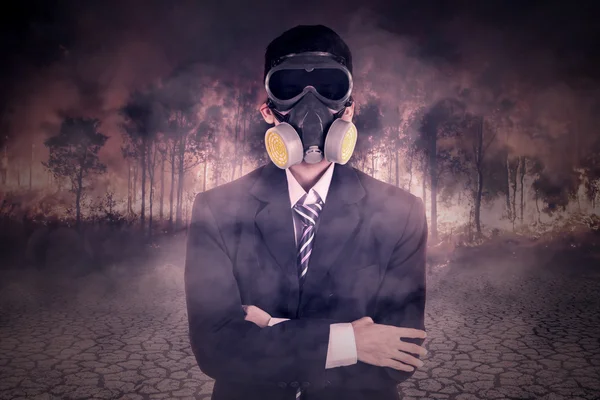 Uomo d'affari con maschera antigas e incendio boschivo — Foto Stock