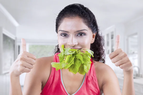 Gelukkige vrouw eet rauwe spinazie — Stockfoto