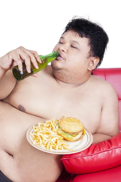 Overgewicht persoon genieten van Hamburger en bier — Stockfoto