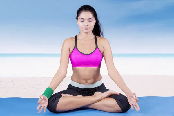 Pretty indian woman meditating at beach — Stock Photo, Image