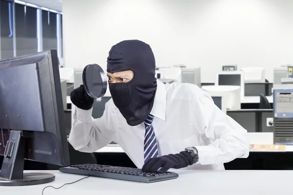Robber with mask looking for information — Stock Photo, Image