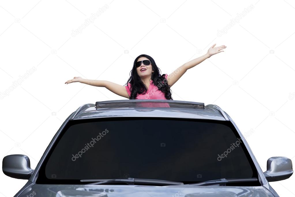 Woman standing on the sunroof of car