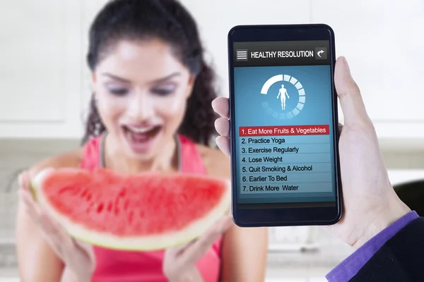 Risoluzioni sane app con donna mangia anguria — Foto Stock