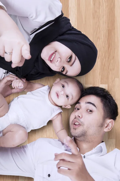Família muçulmana feliz deitada no chão — Fotografia de Stock