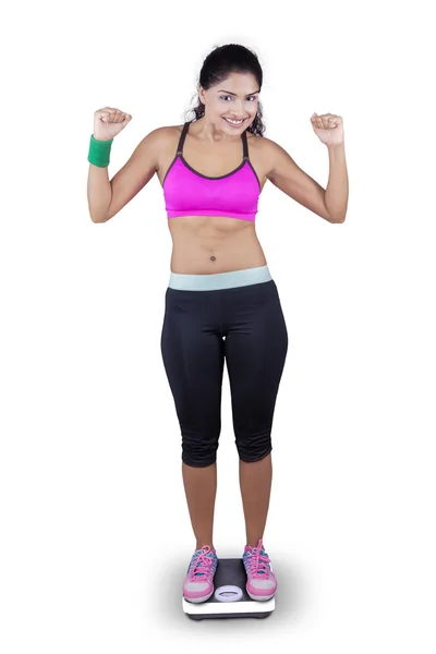 Excited woman stands on weighing scales — Stock Photo, Image