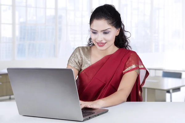 Indisk kvinna med traditionella kläder arbetar på bärbar dator — Stockfoto