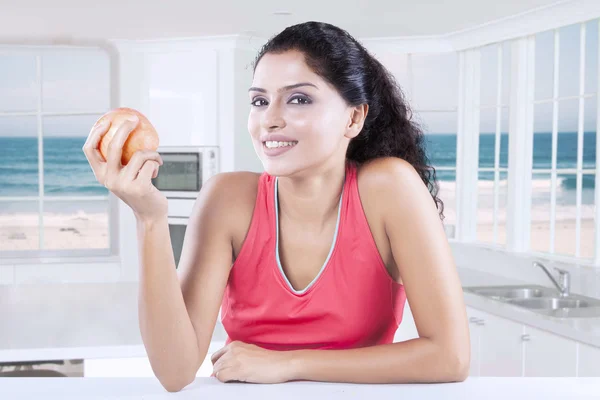 Indiaas model heeft apple in keuken — Stockfoto