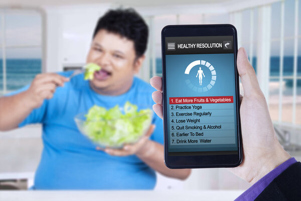 Healthy resolutions app with man eats salad