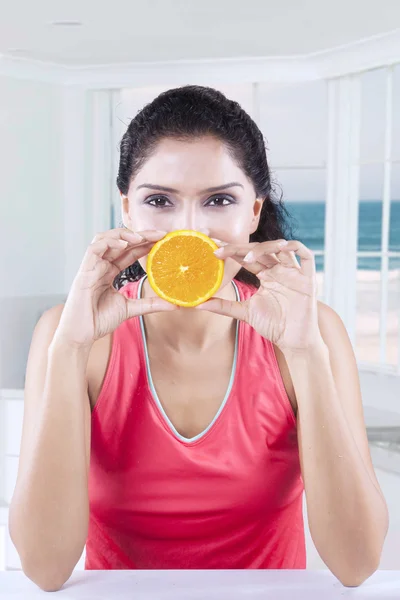 Modelo saudável detém uma fatia de laranja — Fotografia de Stock