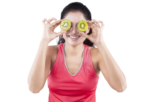 Mulher indiana segurando kiwi frutas em seus olhos — Fotografia de Stock