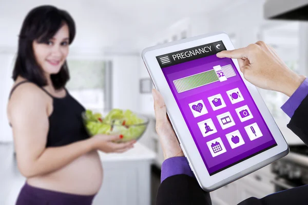 Aplikację ciąży z kobieta w ciąży posiada sałatka — Zdjęcie stockowe