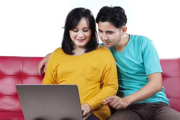 Giovani marito e moglie usano il computer portatile sul divano — Foto Stock