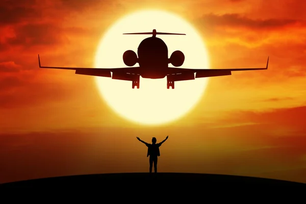 L'homme jouit de la liberté sur la colline sous un avion volant — Photo