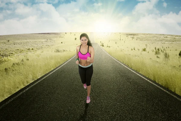 Juoksija tekee liikuntaa tiellä — kuvapankkivalokuva
