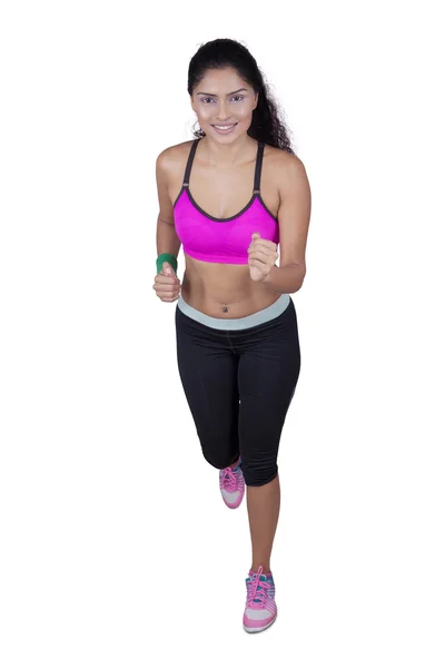 Female athlete running in studio — Stock Photo, Image