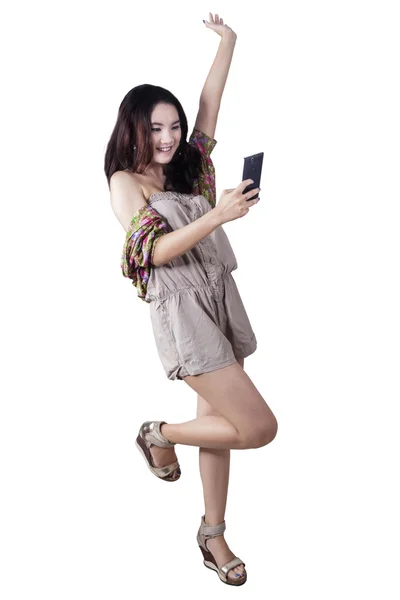 Cheerful girl holds smartphone in studio — Stock Photo, Image