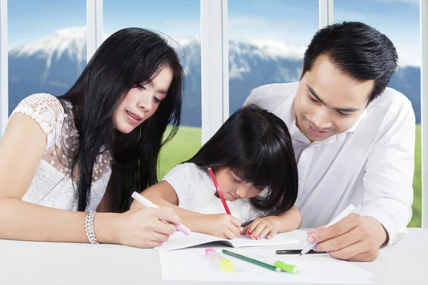 Padre y madre ayudan a su hijo a estudiar — Foto de Stock