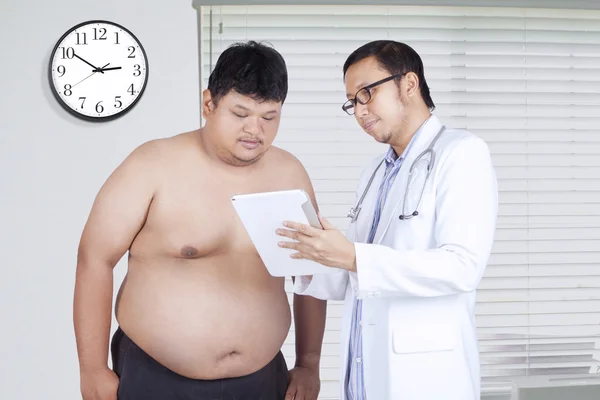Läkare visar testresultatet till fet man — Stockfoto