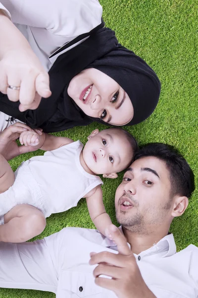 Mutlu bir aile yeşil çim üzerinde yalan — Stok fotoğraf