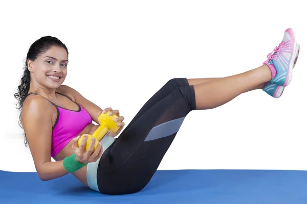 Woman lifting dumbbell and her leg on mat — Stock Photo, Image