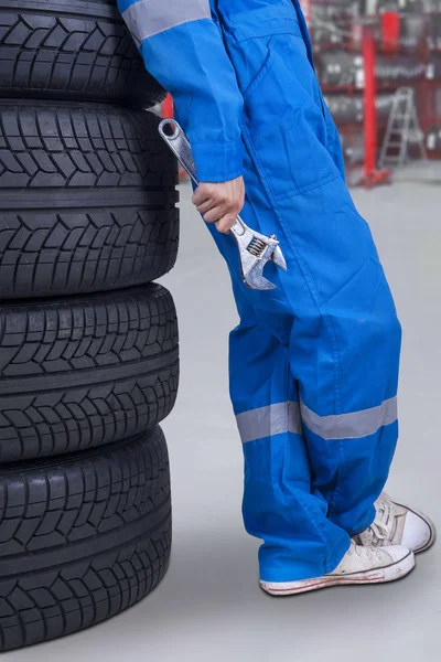Mecánico se apoya en los neumáticos — Foto de Stock