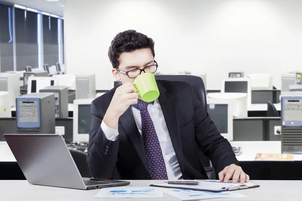 Unternehmer trinkt Kaffee am Arbeitsplatz — Stockfoto