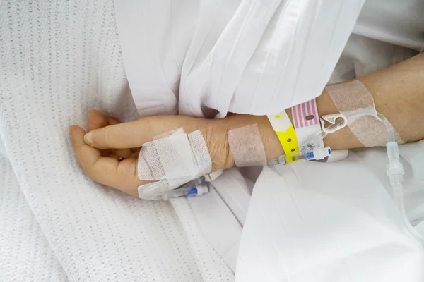 Roztwór soli fizjologicznej w ręku pacjenta — Zdjęcie stockowe