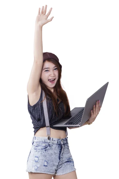 Teenage girl with arms raised using laptop — Stock Photo, Image