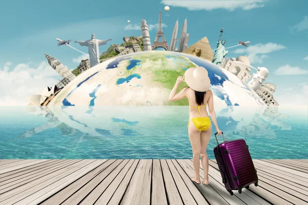 Toerist met de bikini en de wereld-mijlpaal — Stockfoto
