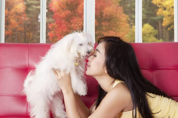 Junge Frau küsst ihr Haustier auf dem Sofa — Stockfoto