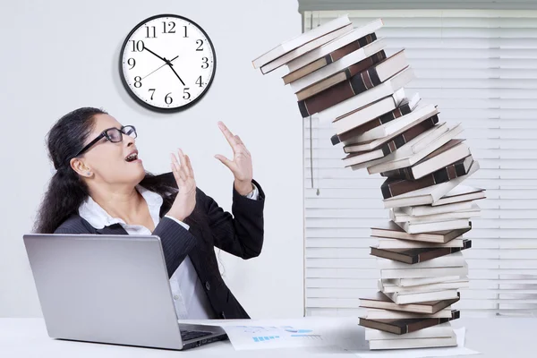 Overworked Indian entrepreneur holds falling books Stock Picture