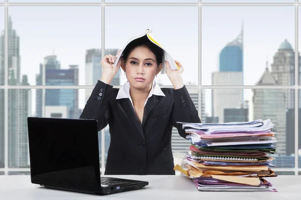 Verveeld werknemer zet papierwerk op haar hoofd — Stockfoto