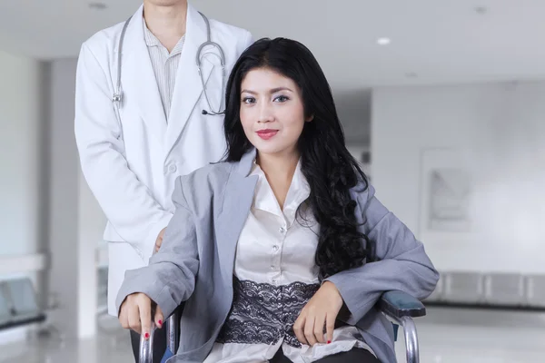 Female patient sits on wheelchair in corridor — Stock Photo, Image