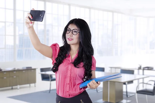 Trabajadora tomando selfie en la oficina — Foto de Stock