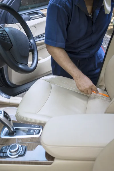 Maschio lavoratore strofinando il seggiolino auto — Foto Stock